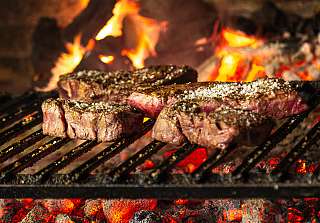 Steaks fraîchement grillés sur des braises ardentes lors de la soirée barbecue du jeudi au Sunstar Hotel Klosters