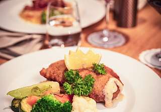 Cordon-bleu maison avec légumes de saison et vin rouge à la Chäs Stuba du Sunstar Hotel Klosters